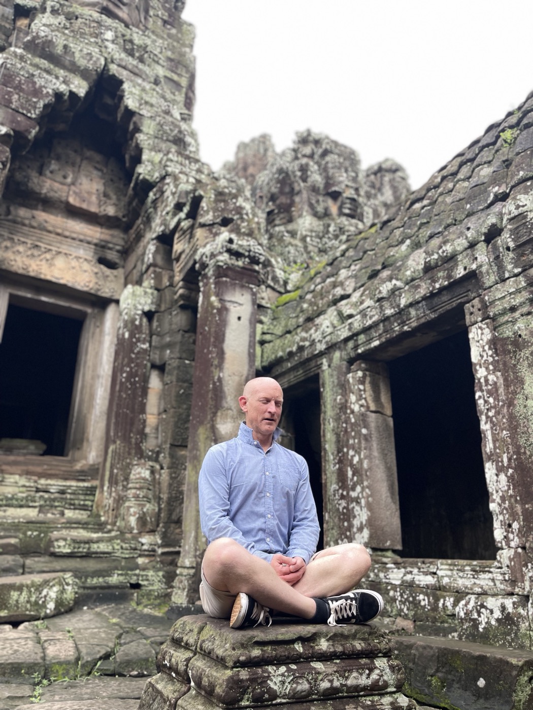 Dave, yoga teacher at b.YOGA Practice, in seated meditation at the Bayon temple in Angkor, Cambodia